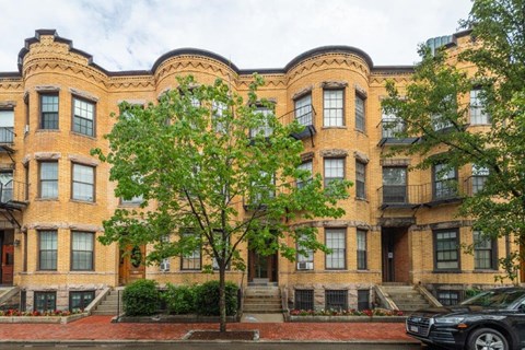 a large brick building with a tree in front of it